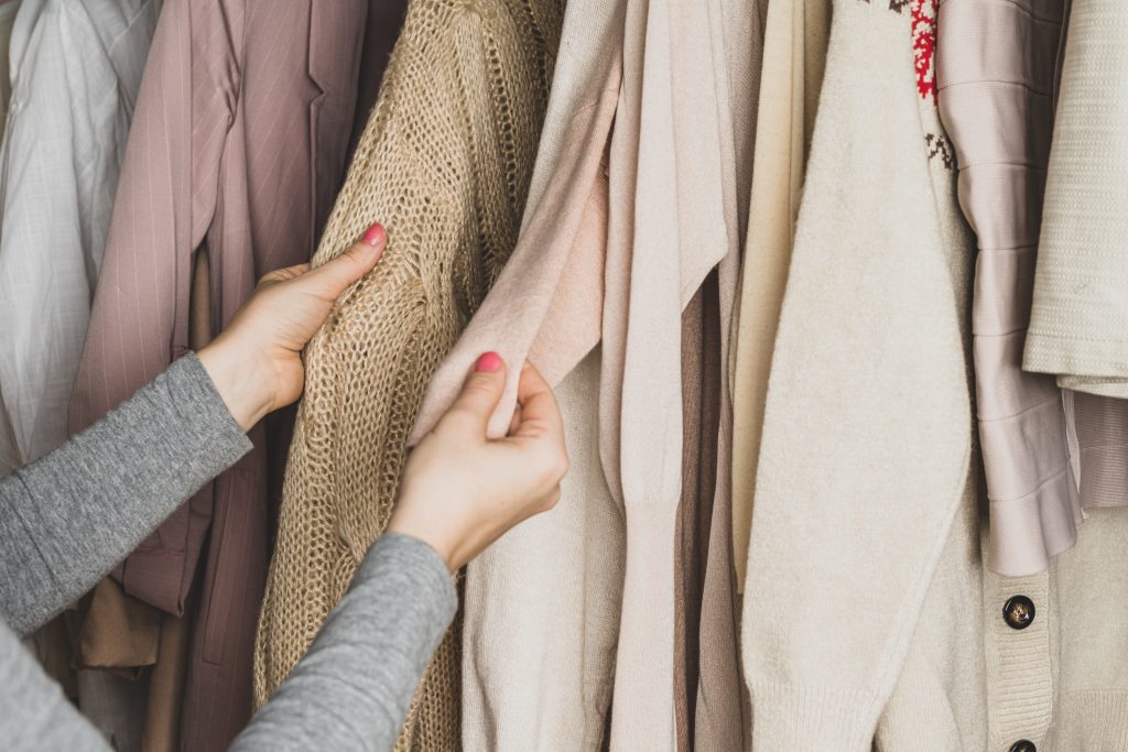 Woman comparing and choosing two different woolen sweaters