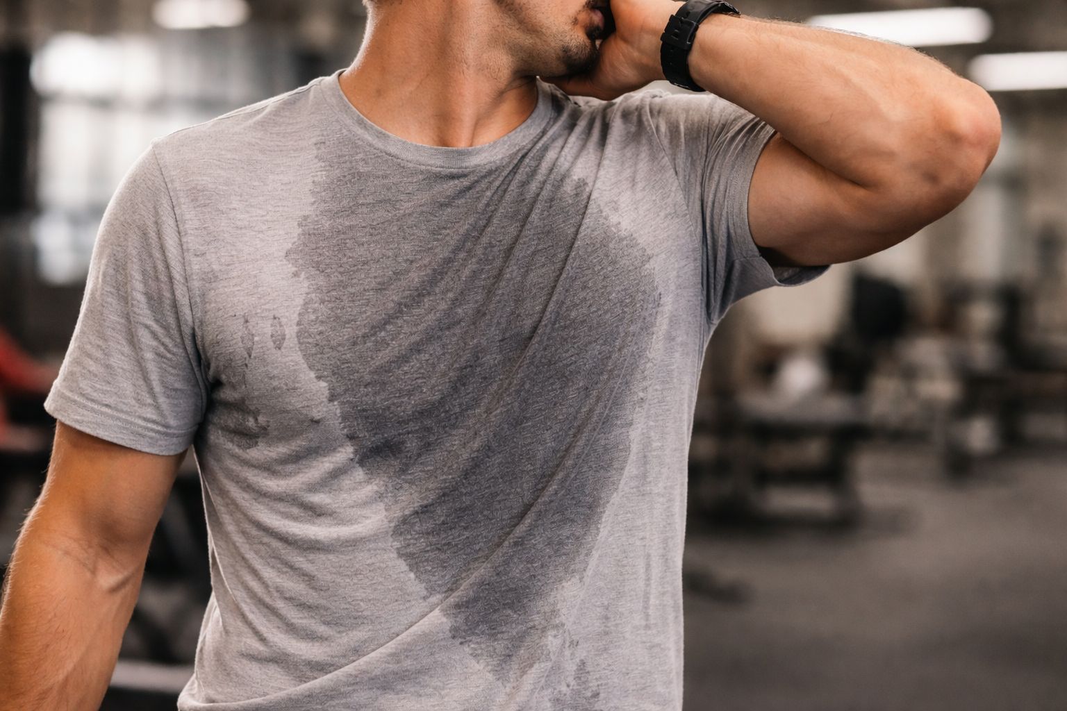 An athlete looking uncomfortable in a sweat-soaked cotton shirt at the gym