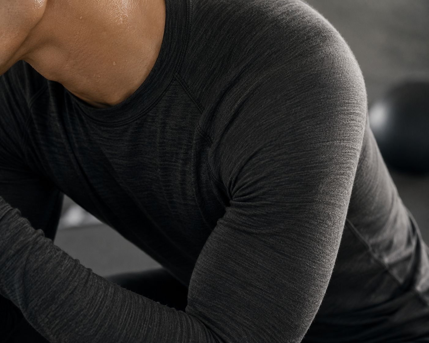 A close-up of a person comfortably wearing a wool base layer during a workout, with skin that looks dry.